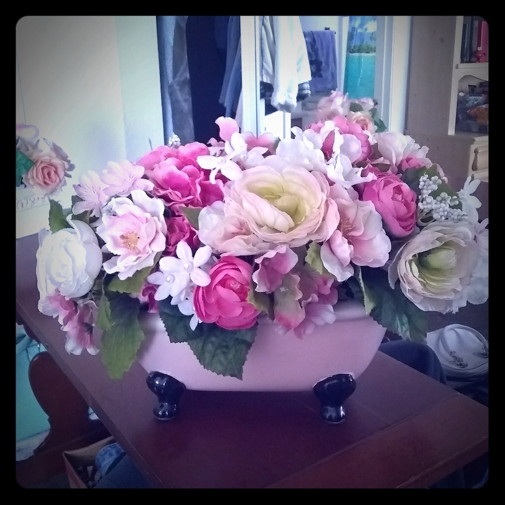 Clawfooted ceramic bathtub with flowers.